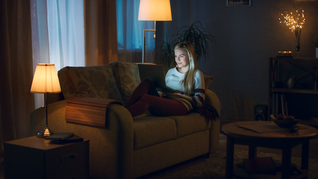 Woman on couch with multiple lamps surrounding her